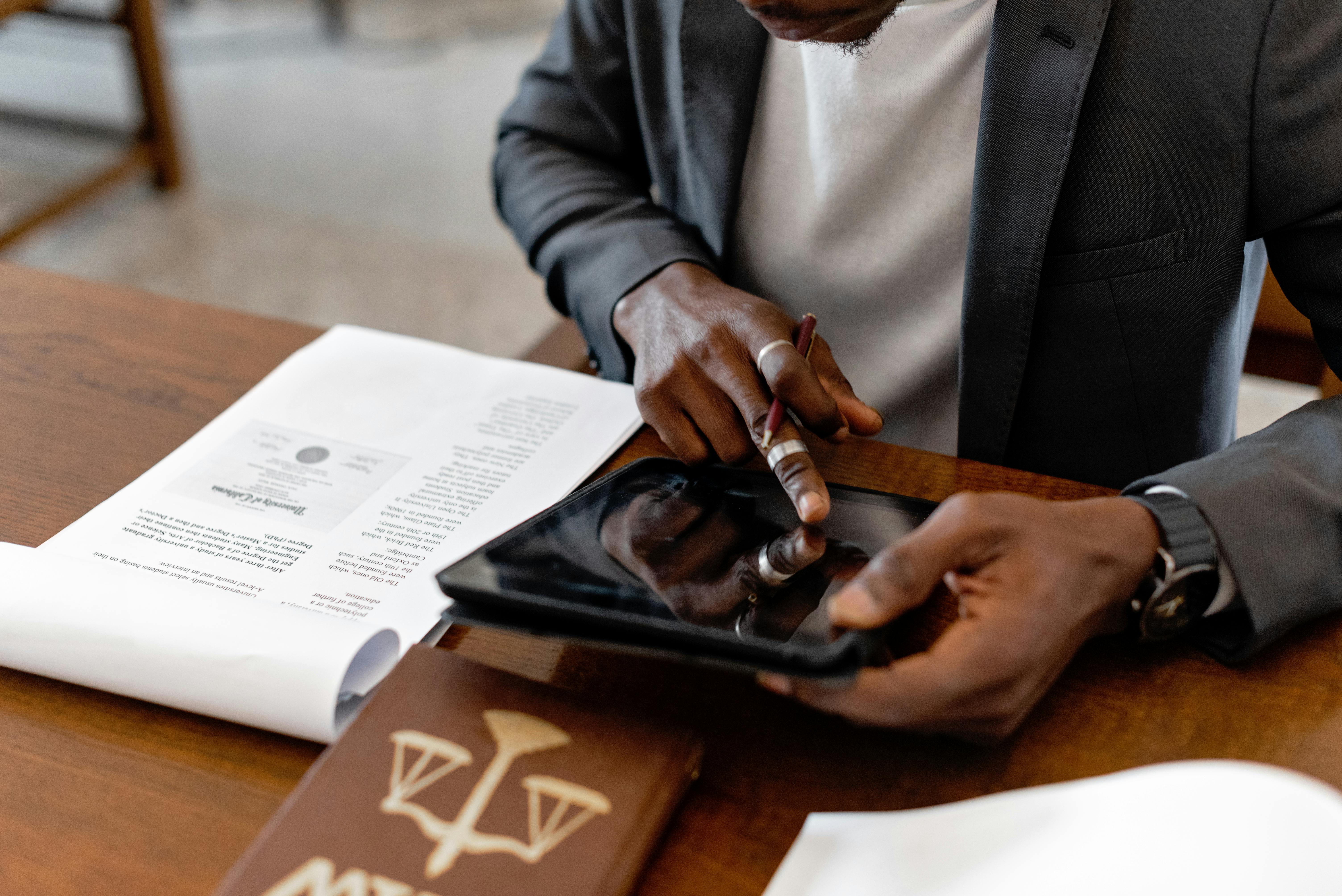 Close-up of a professional working on a digital tablet in an office setting.